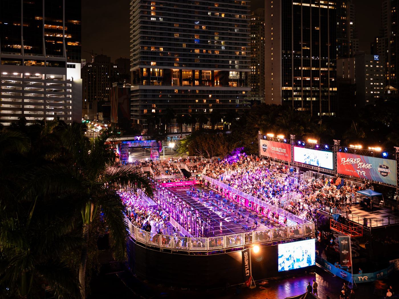 The barge stage lit up at night beneath downtown Miami towers
