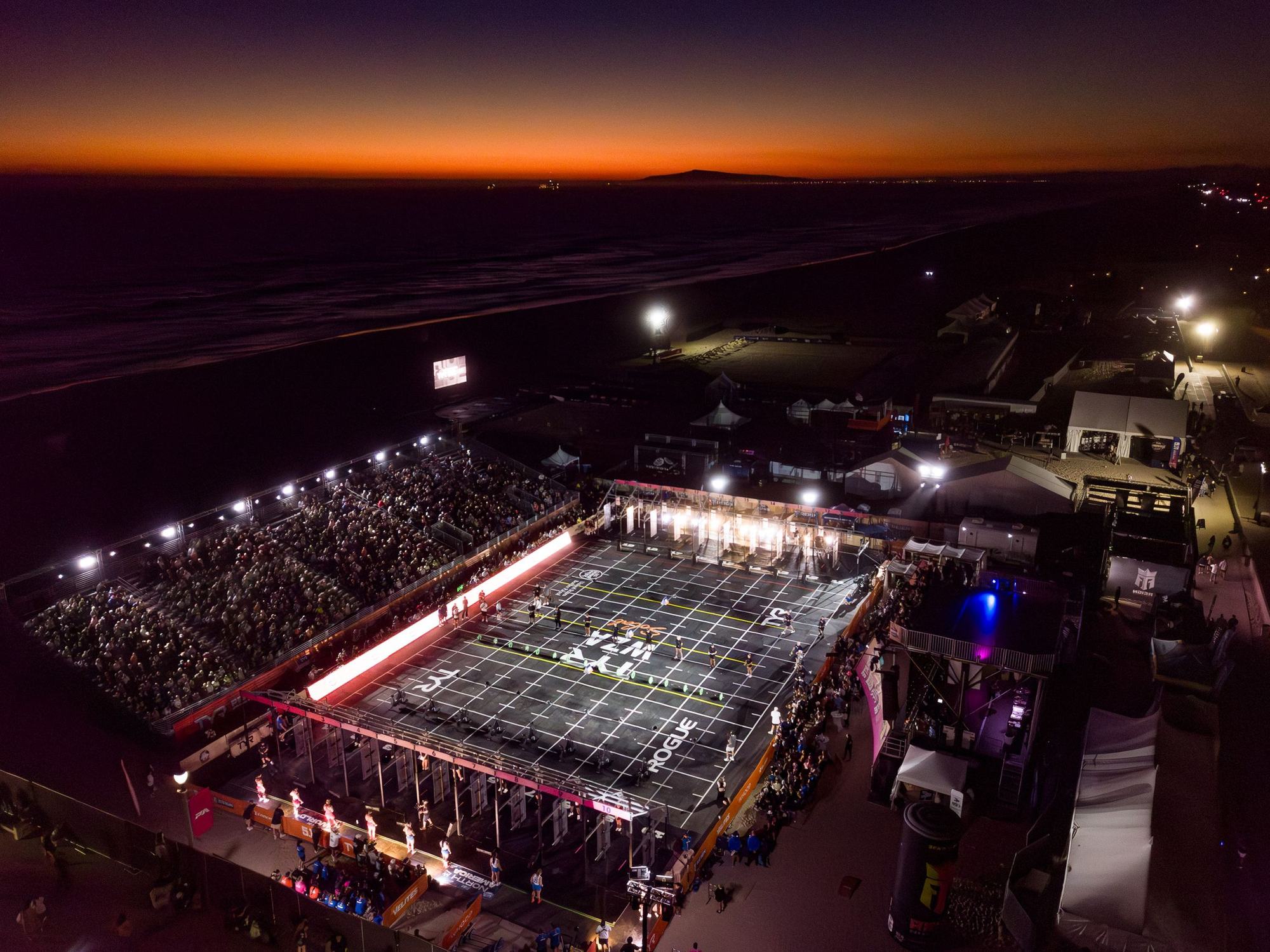 Night drone view of the lit arena on Huntington Beach