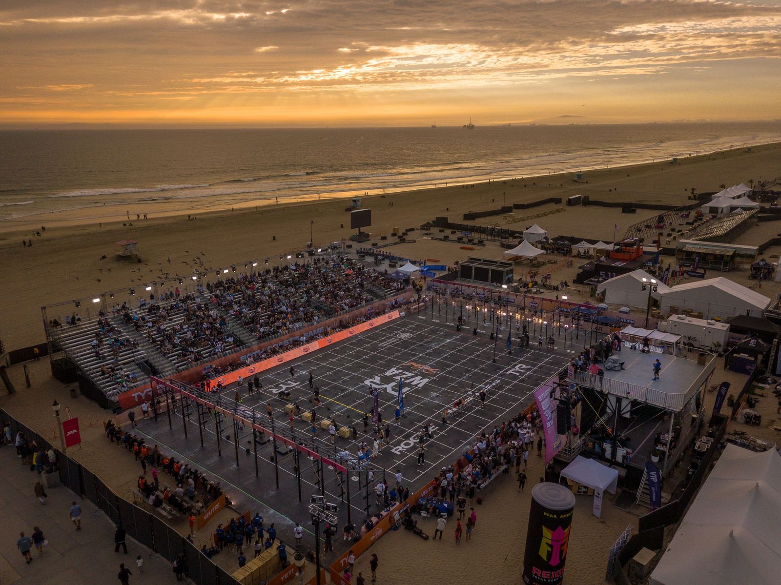 Drone view of the full arena on Huntington Beach at sunset, the Pacific behind it