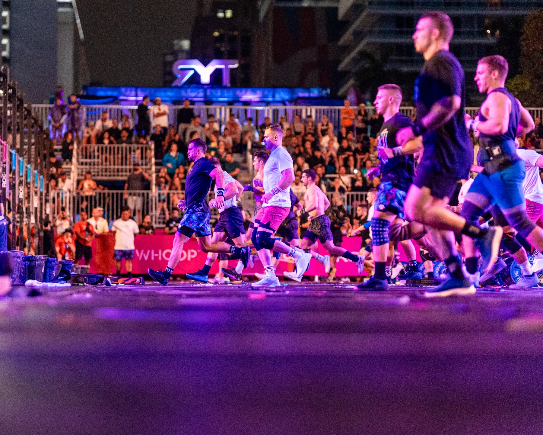 Athletes competing under purple arena lights at Wodapalooza